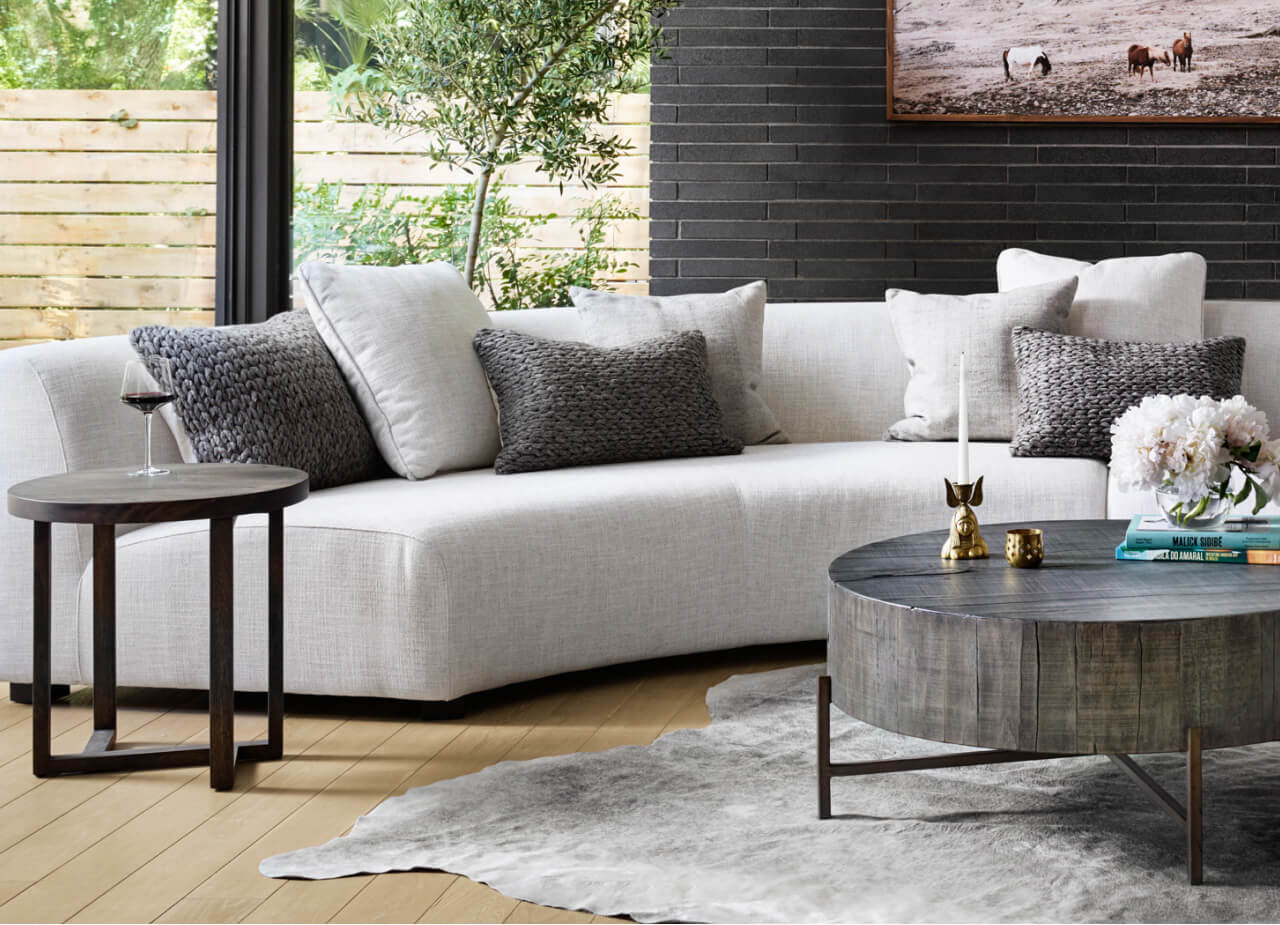 A sleek living room design with a cozy couch, a coffee table, and two matching side tables for added functionality.