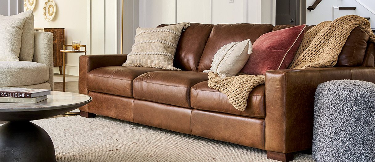 A modern living room with a brown leather couch and chair, enhancing the space's elegance and comfort.