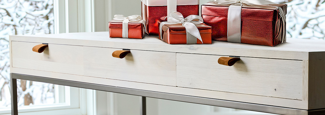 A white console table adorned with red and white presents, creating a festive and inviting atmosphere.