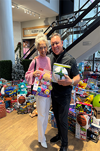 Heather with Boston 25 infront of gifts