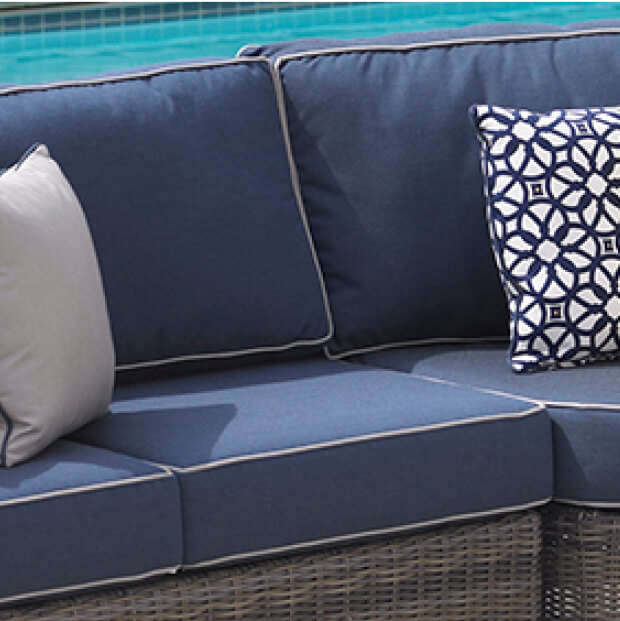 Sunbrella sofa with pillow set in front of a pool