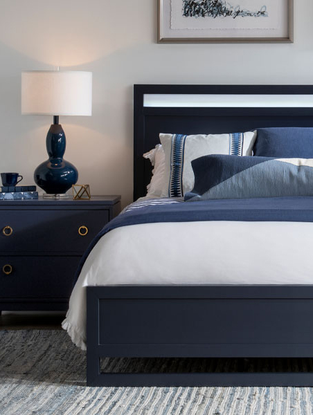 Serene bedroom featuring blue and white color scheme, bed, and nightstand.