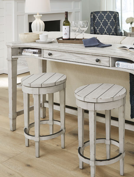 White table with two wooden stools in kitchen.