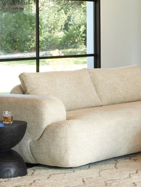 Large sectional sofa positioned in front of a window, inviting comfort and sunlight.