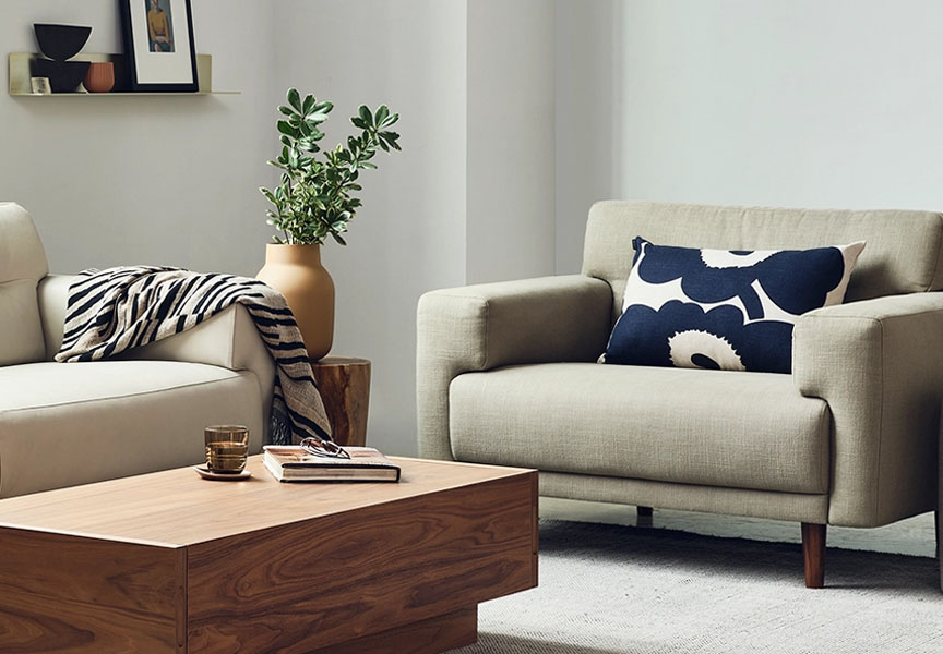 A cozy living room with a couch, chair, and ottoman.