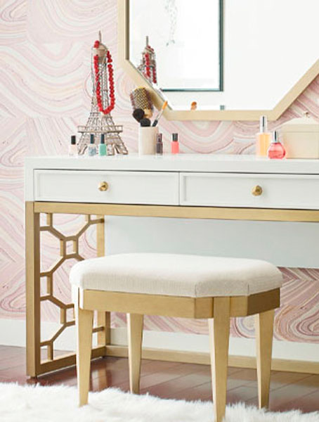 A white vanity with gold trim and a matching stool.