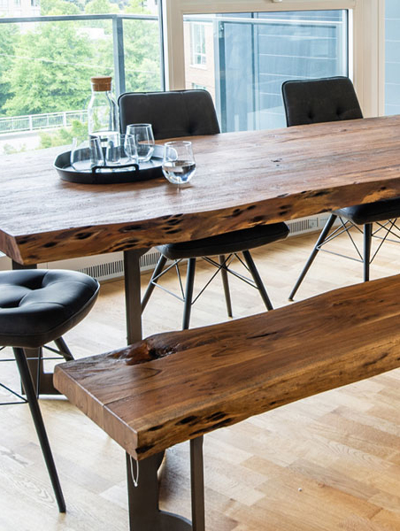 A dining table with a bench and chairs, set for a family meal in a cozy kitchen.