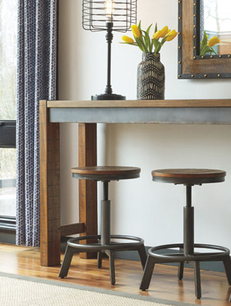 A wooden table with a mirror on top, flanked by two stools.