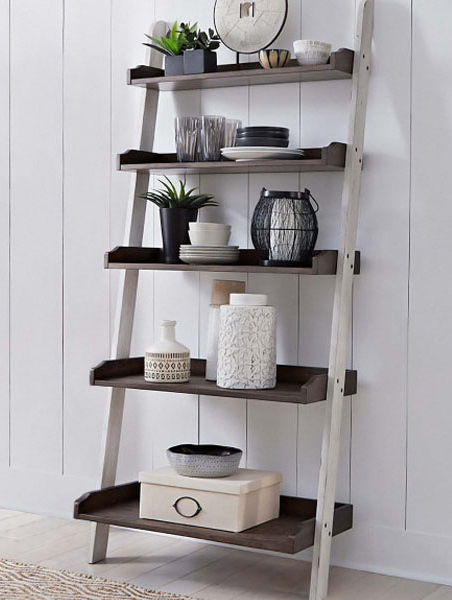 A ladder shelf against a white wall, featuring a wooden shelf displaying decorative items and plants.