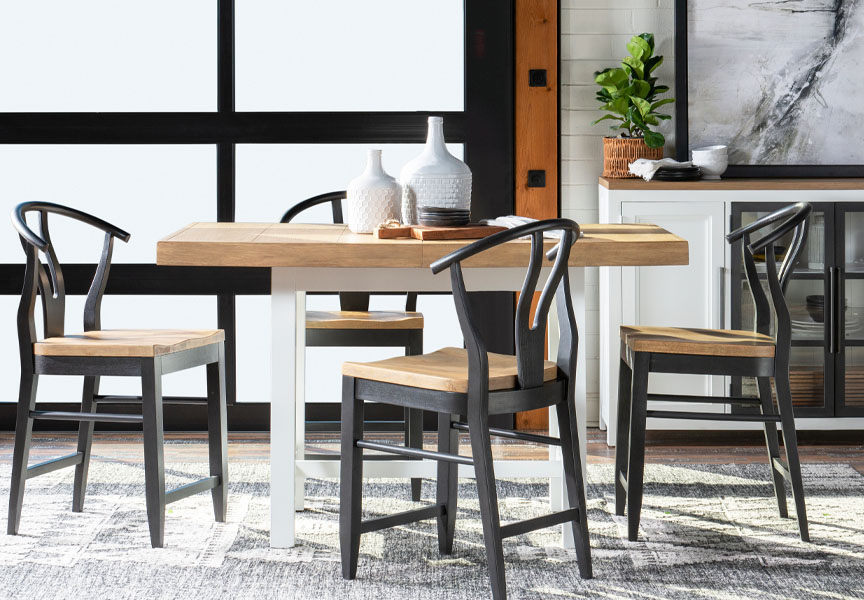 A wooden dining table with four chairs arranged around it.