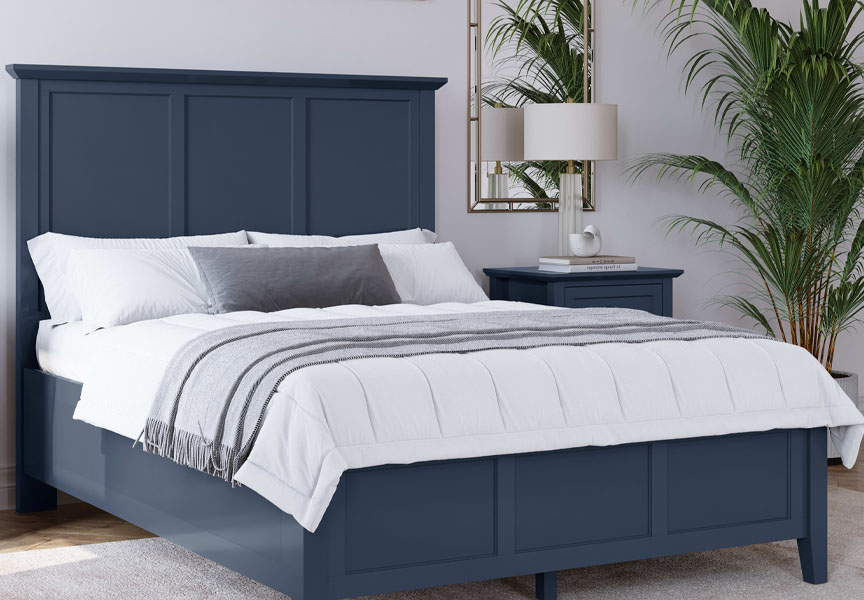 Bed with sleek dark blue frame and headboard, topped with white linens.