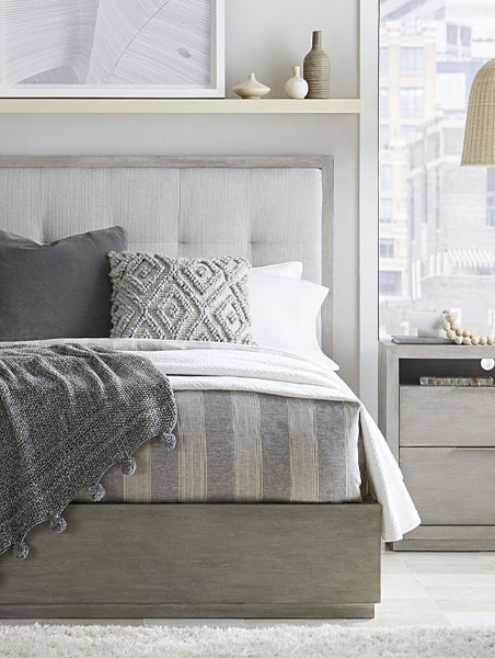 Sleek bedroom featuring gray bed and white nightstand.