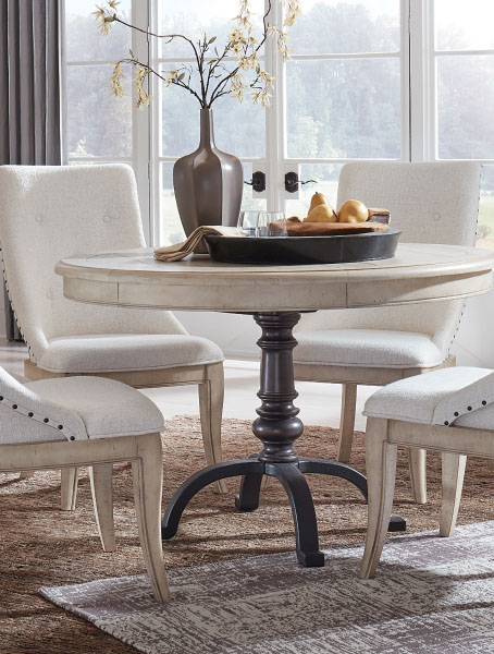 A round dining table with four chairs in a cozy dining room setting.