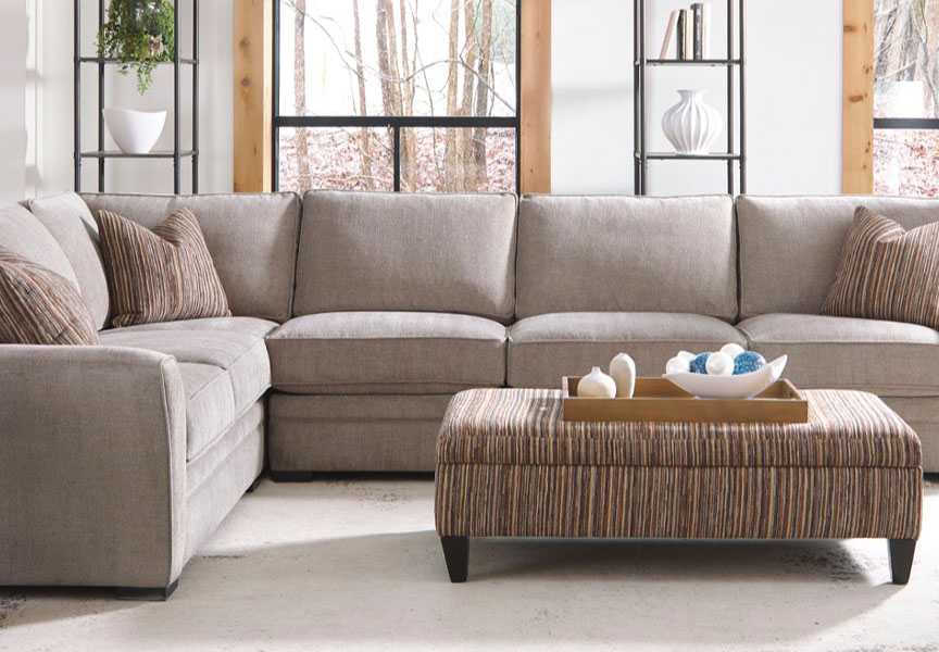 Image of a large sectional couch with pillows and ottoman, creating a comfortable seating area.