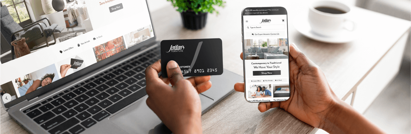 Hand holding Jordan's credit card in one hand while scrolling through Jordans.com on a phone in the other hand 