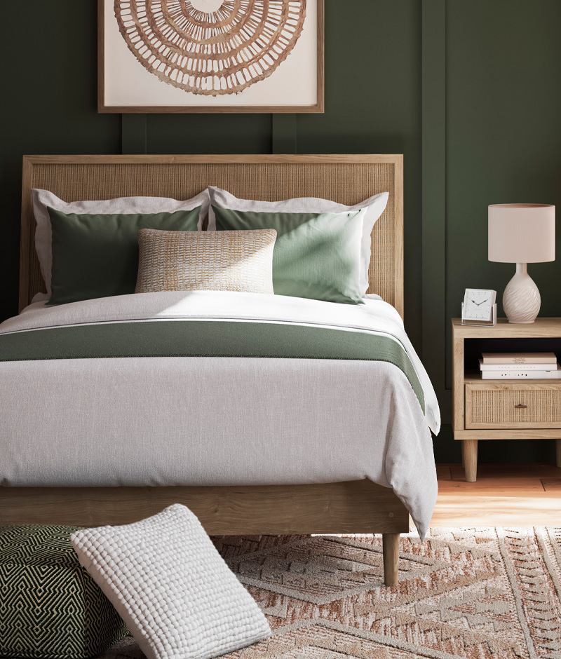 A cozy bedroom featuring green walls and a wooden bed, creating a serene and inviting atmosphere.