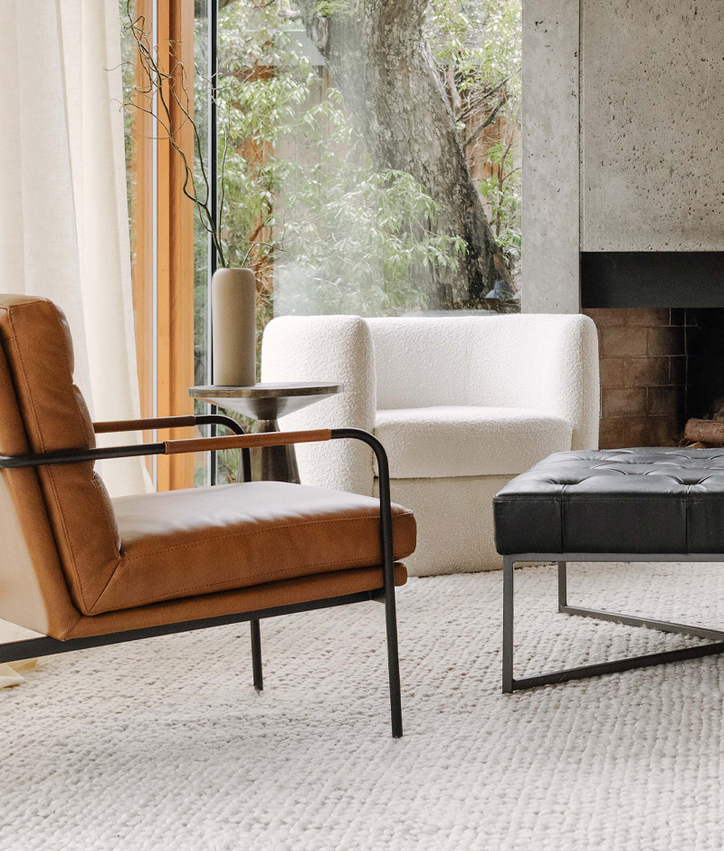 A modern living room showcasing a sleek leather chair alongside a complementary ottoman, creating a welcoming atmosphere.