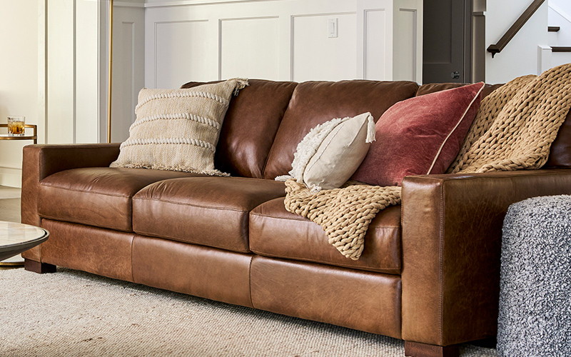 A brown leather couch positioned in a cozy living room setting, enhancing the room's warmth and comfort.