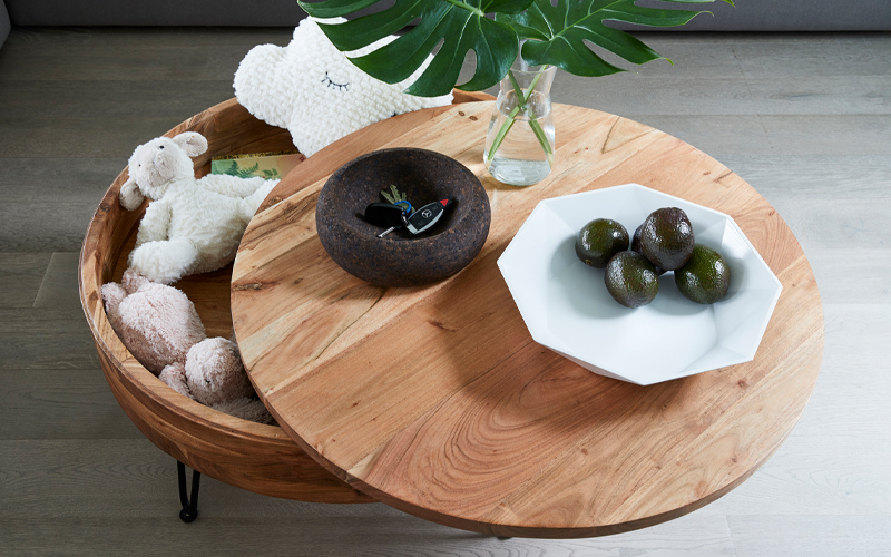 A wooden table adorned with a basket of plants and a charming stuffed animal, creating a cozy atmosphere.