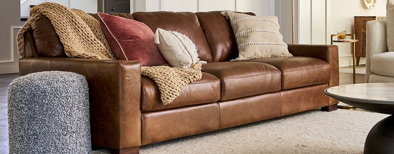 A brown leather couch and chair set in a living room, enhancing the space with elegance and warmth.