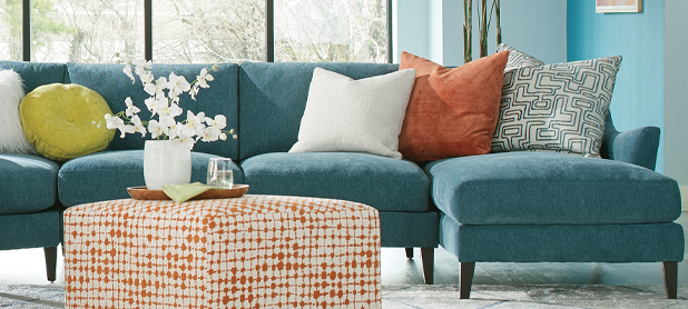 A blue sectional couch adorned with vibrant orange pillows, creating a stylish and inviting living space.