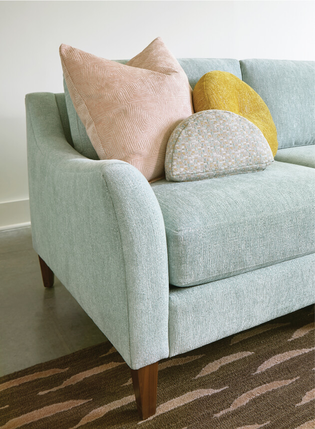 Design Lab teal sofa with pink, yellow and white pillow