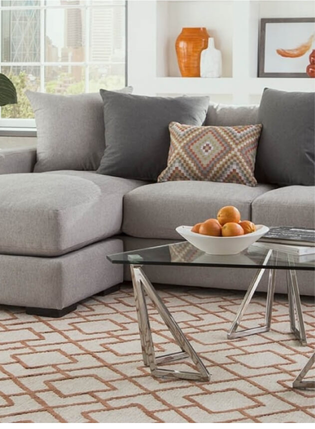 Lombardy grey sectional in front of glass table with oranges in bowl